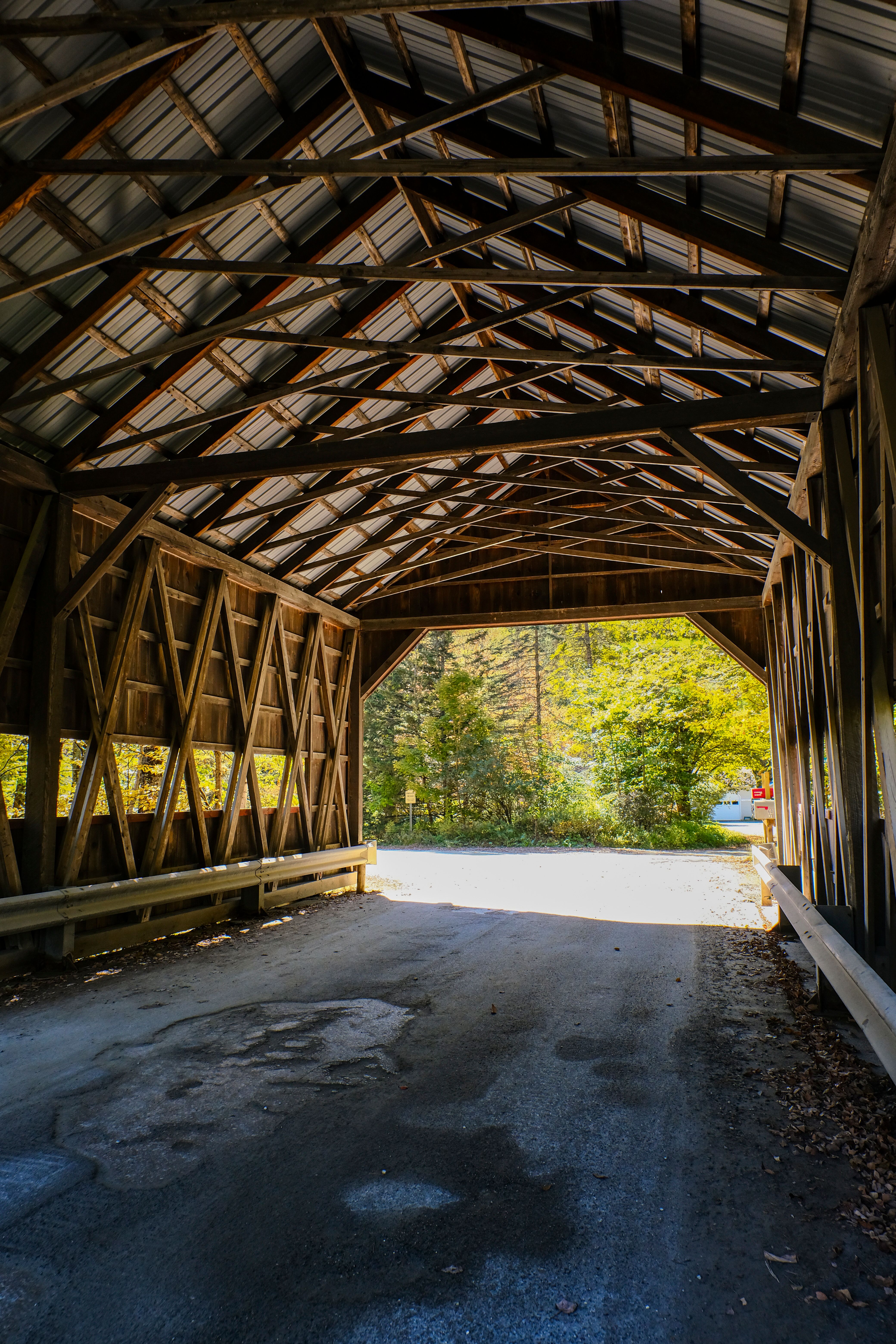 A classic wooden covered bridge with sunlight streaming in, capturing the essence of autumn.