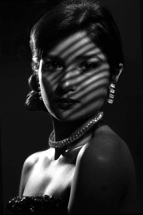 Grayscale Portrait Photo of Blinder Light Shadow on Woman's Face