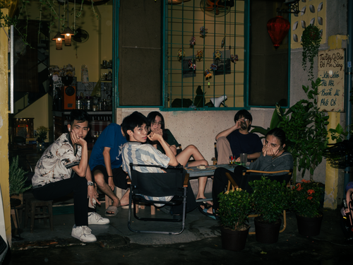 Free Group of friends enjoying a casual evening at an outdoor cafe setting. Stock Photo