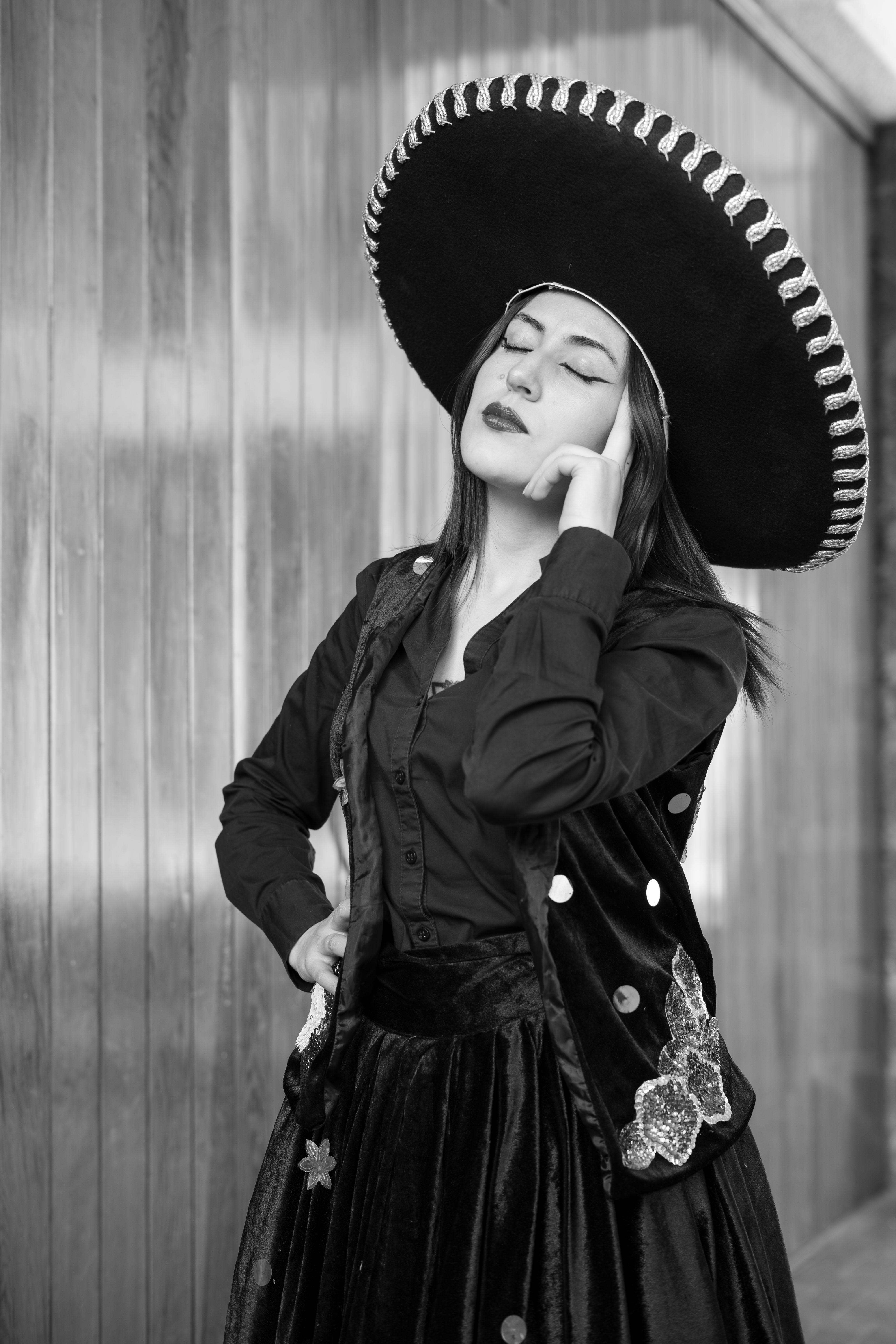 Elegant black and white portrait of a woman wearing a traditional Mexican sombrero and attire.