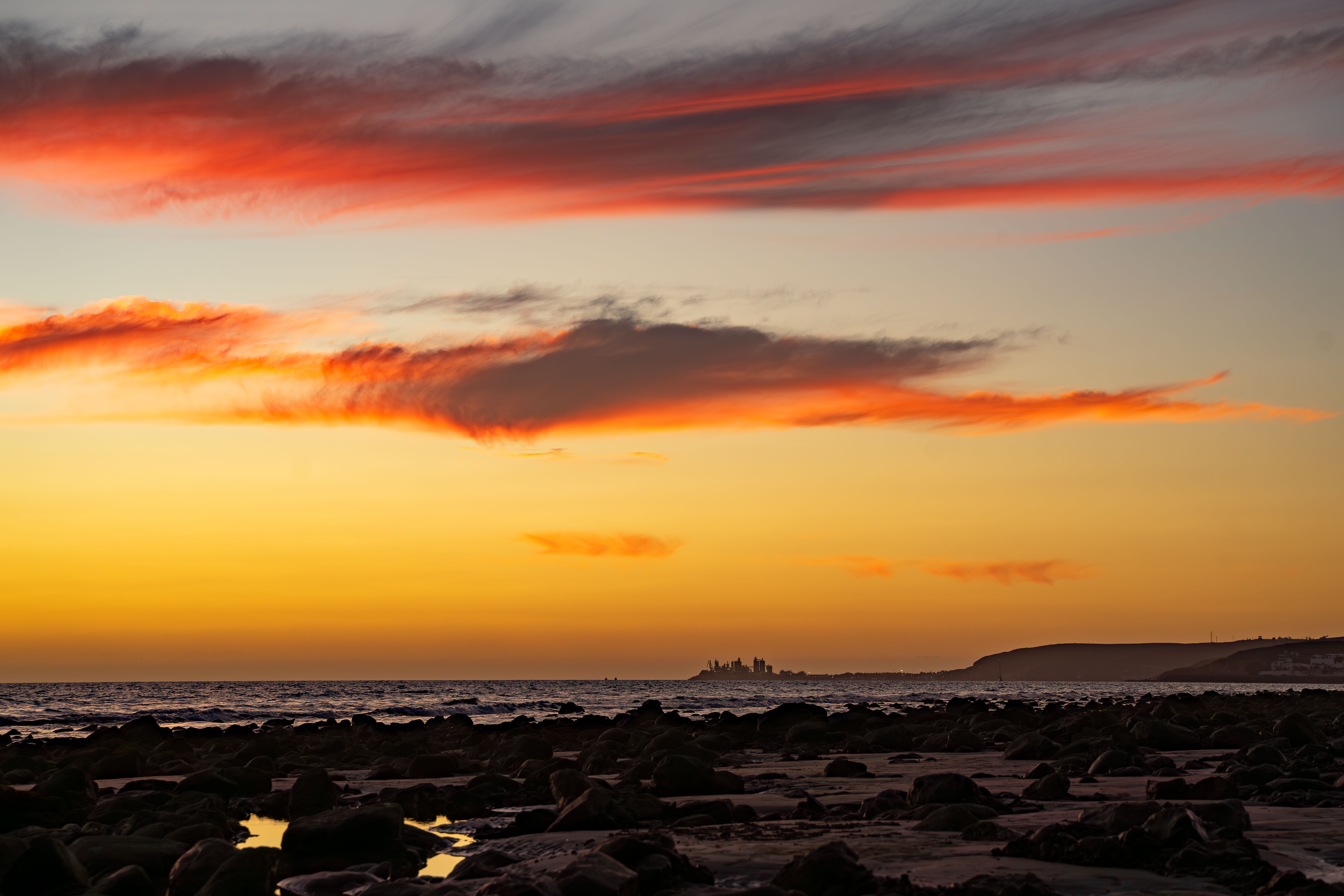 Dramatic Sunset Over Coastal Skyline · Free Stock Photo
