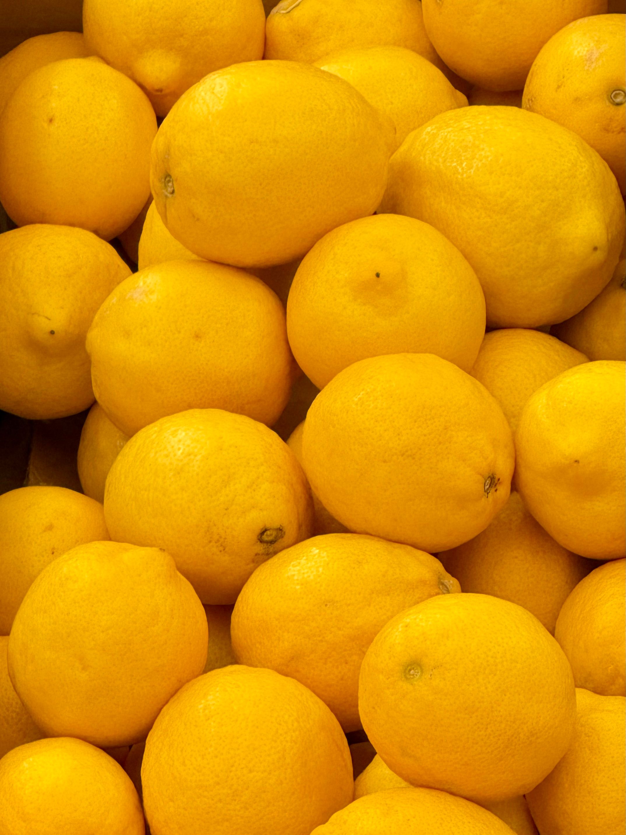 A vibrant pile of fresh yellow lemons at a market in Ascot Vale, VIC, Australia.