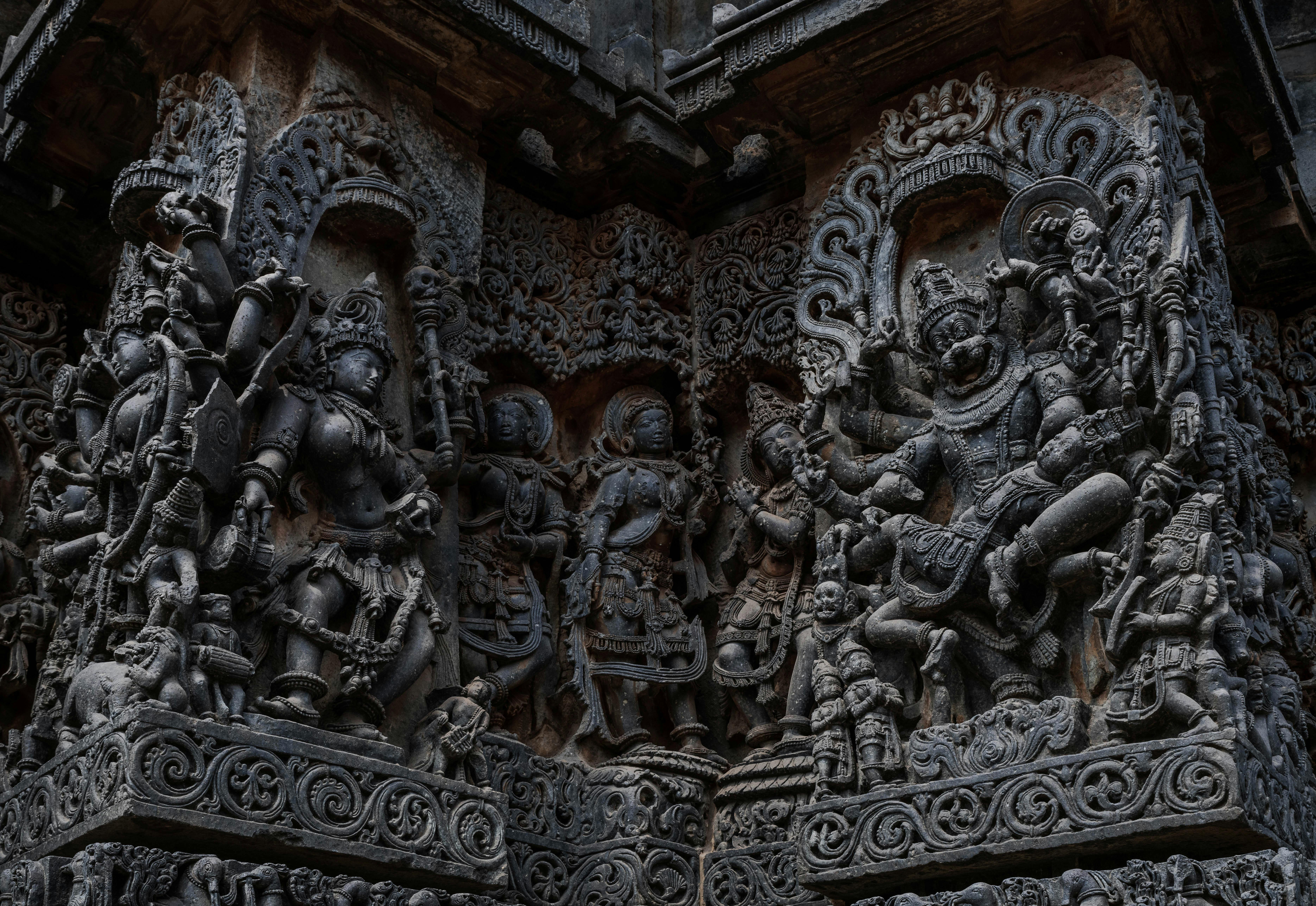 Detailed stone carvings at Halebidu temple, depicting Hindu gods and mythology.