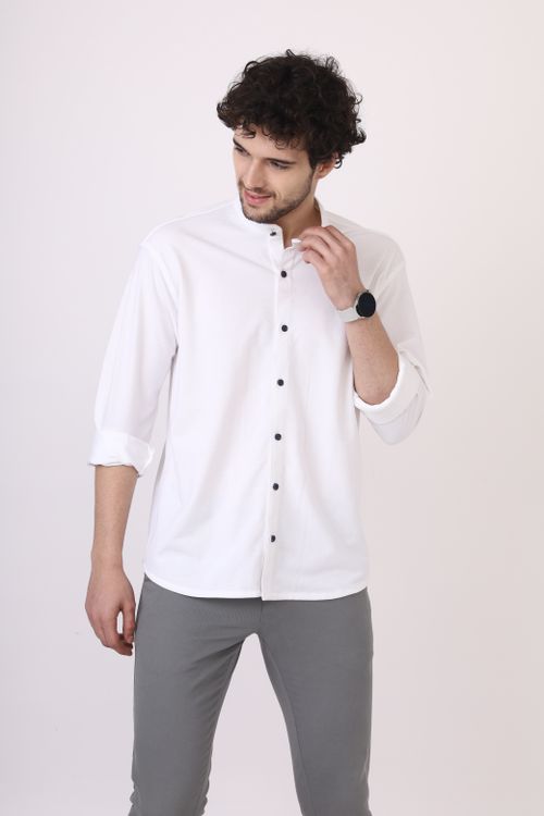 Free Young man wearing a white shirt and smartwatch in a casual studio setting Stock Photo