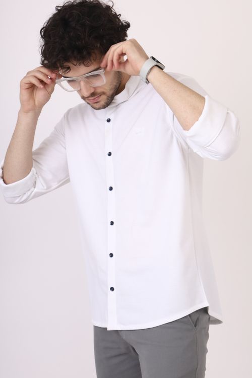 Free Man with curly hair in a modern white shirt adjusting glasses. Studio shot. Stock Photo
