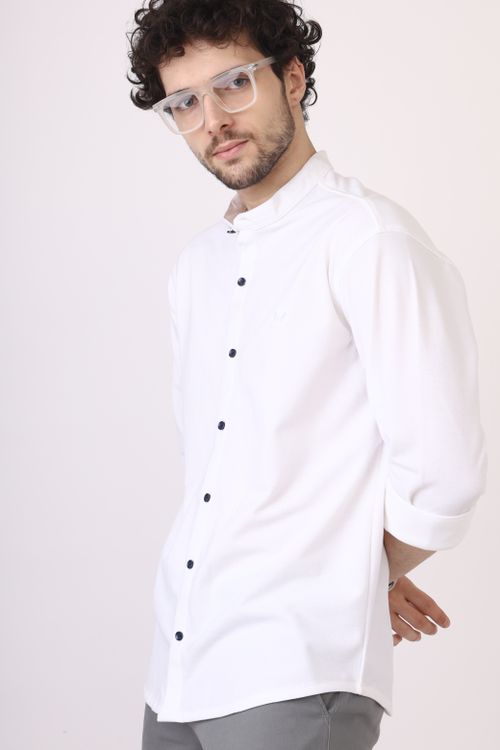 Free Portrait of a stylish young man wearing a white shirt and glasses in a modern, minimalist setting. Stock Photo