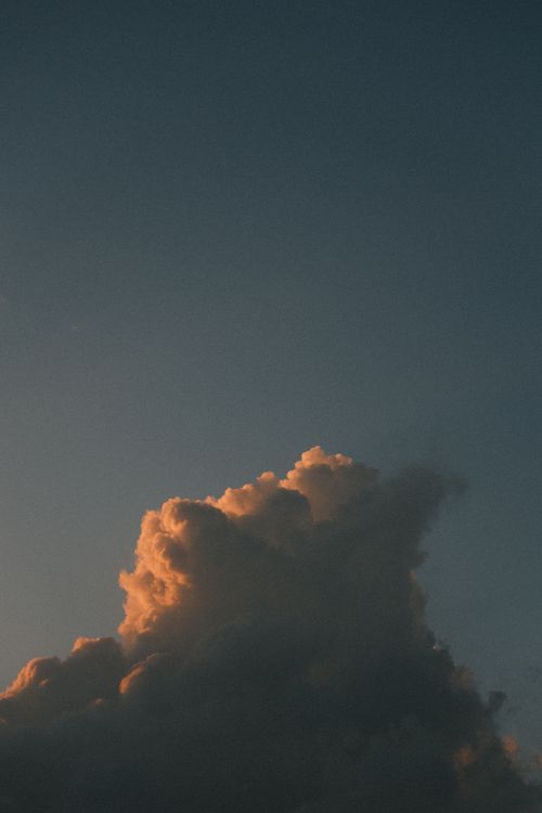 Free Dramatic cloud formation against a twilight sky with warm orange glow. Stock Photo
