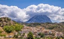 山间坐落着一个迷人的西班牙村庄，天空阴沉，非常适合旅行爱好者