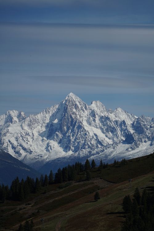 Free A breathtaking view of a snow-capped mountain under a blue sky. Stock Photo