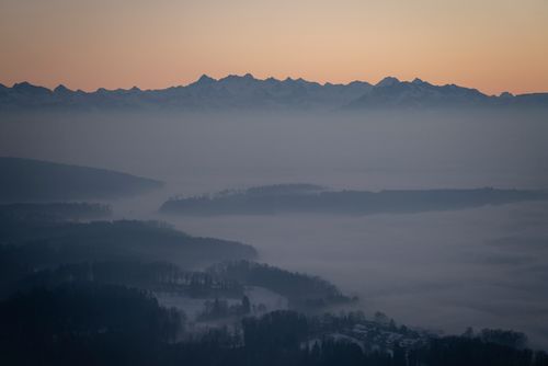 Free Misty mountain range at sunrise with soft light over a foggy landscape. Stock Photo