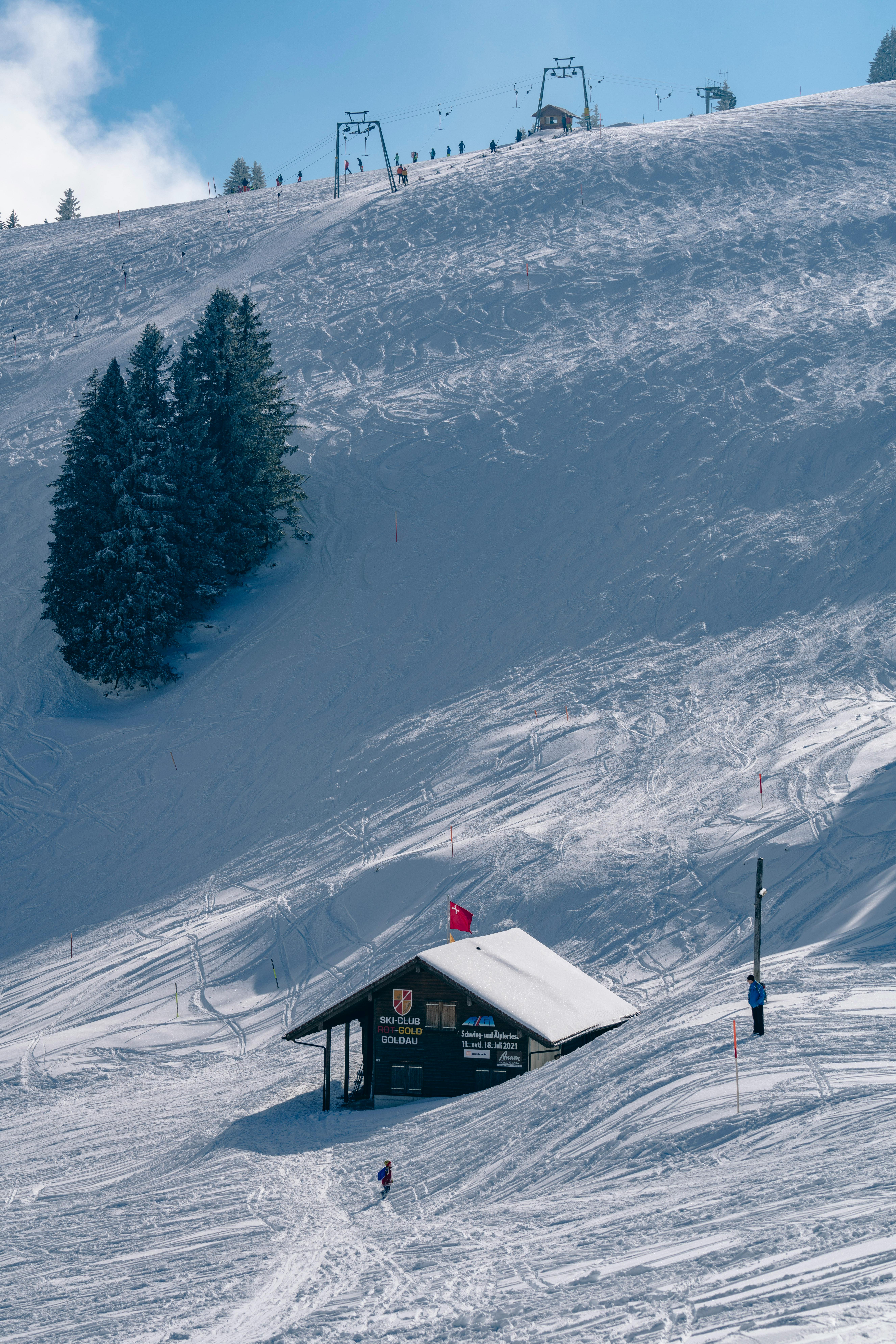 Prescription Goggle Inserts - A picturesque snowy mountain slope with a ski lodge and chairlifts under a clear blue sky.