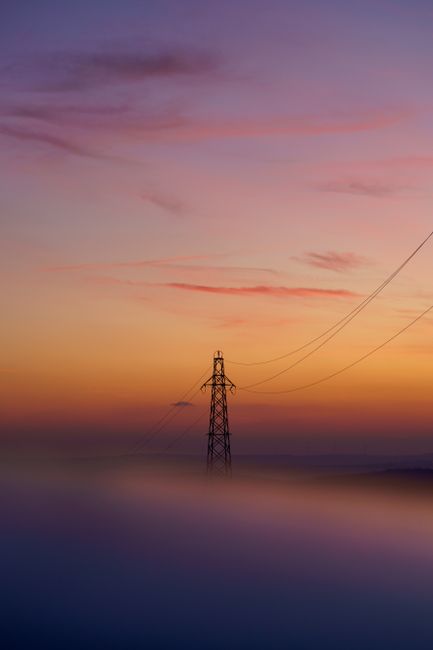 A tranquil sunset scene with power lines emerging from a misty landscape in Çatalca, Istanbul.