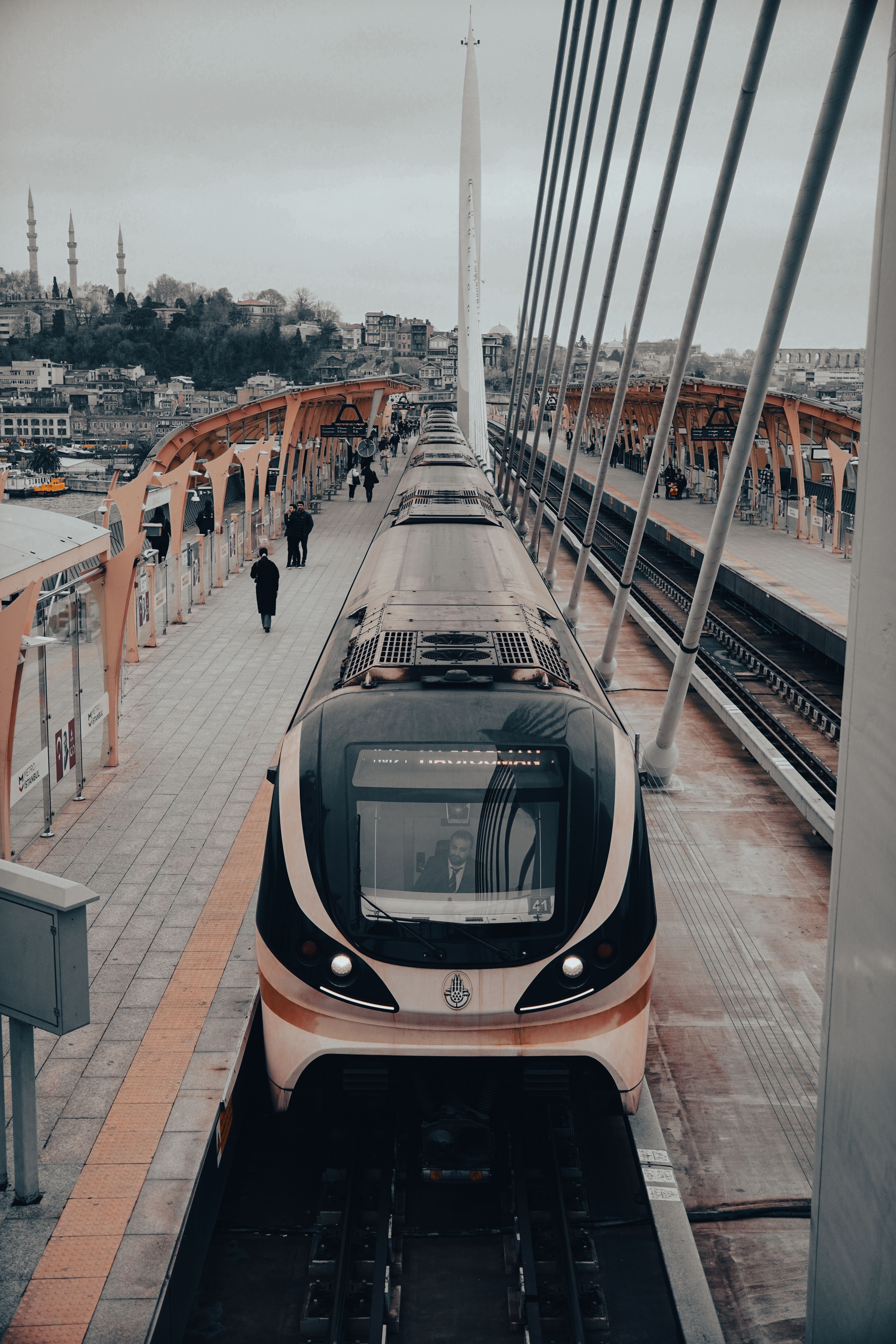 A modern tram crossing the Halic Bridge in Istanbul, showcasing urban life and architecture.