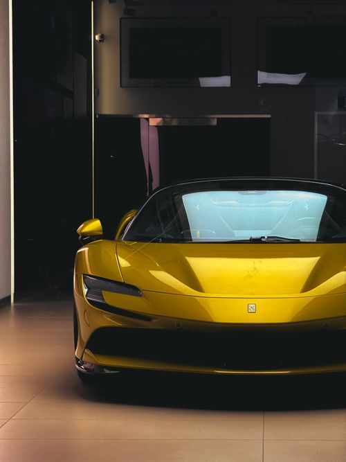 Free Sleek yellow sports car showcased in a Toronto showroom, radiating luxury and style. Stock Photo