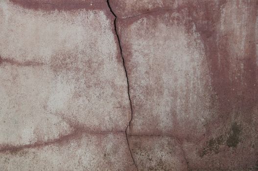Close-up of an aged concrete wall with prominent crack, depicting texture and wear.