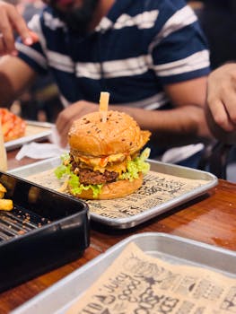 Close-up of a gourmet cheeseburger on a tray in a casual dining environment, perfect for food enthusiasts.