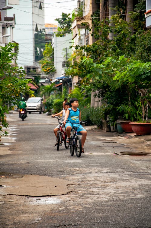 Photo of Two Boys  Riding Bikes on the Street