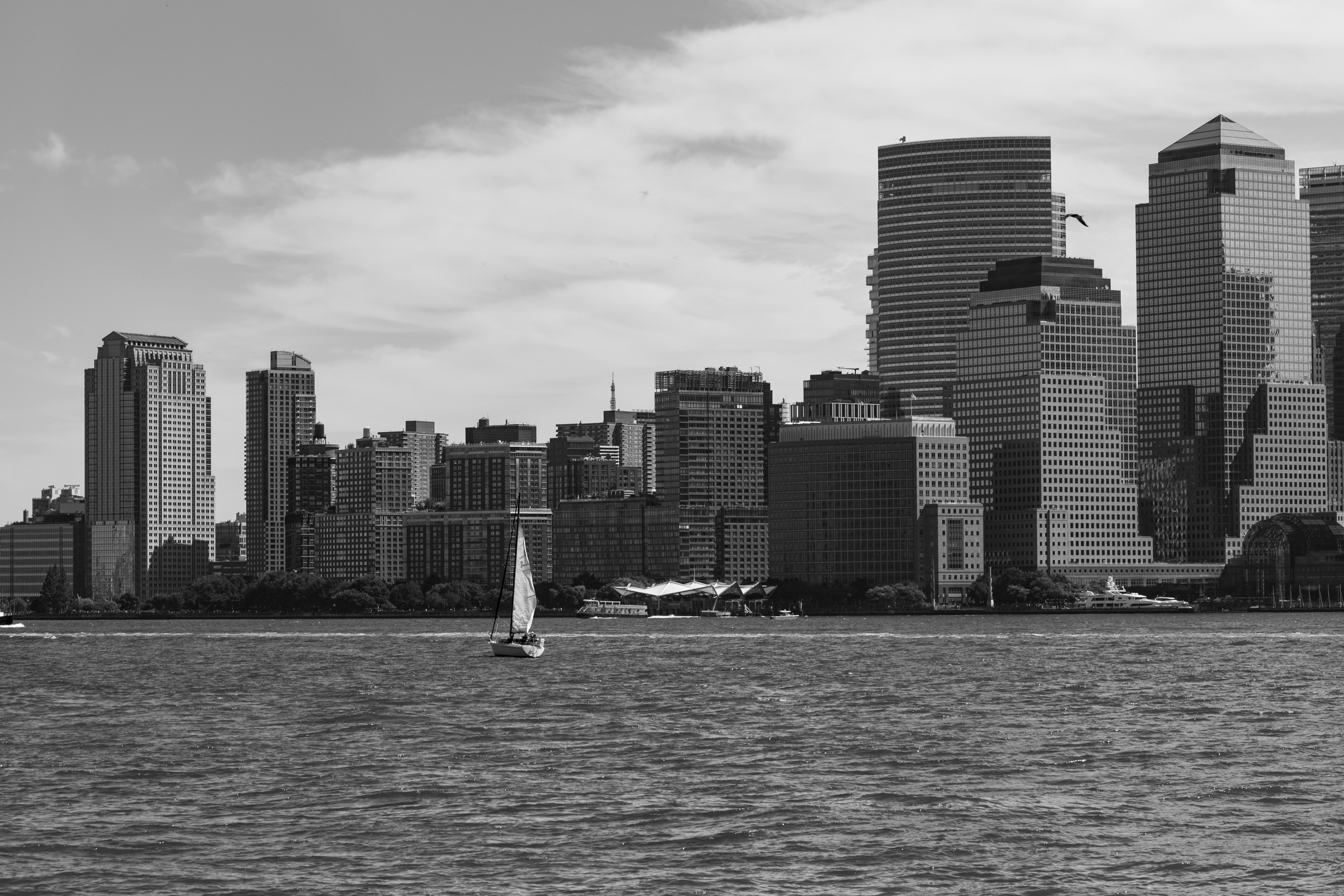 Amazing New York City Christmas Holiday Lights Sightseeing Cruise Review: A Magical Night on the Hudson Review 2026 - Black and white photo of city skyline with sailboat on river.