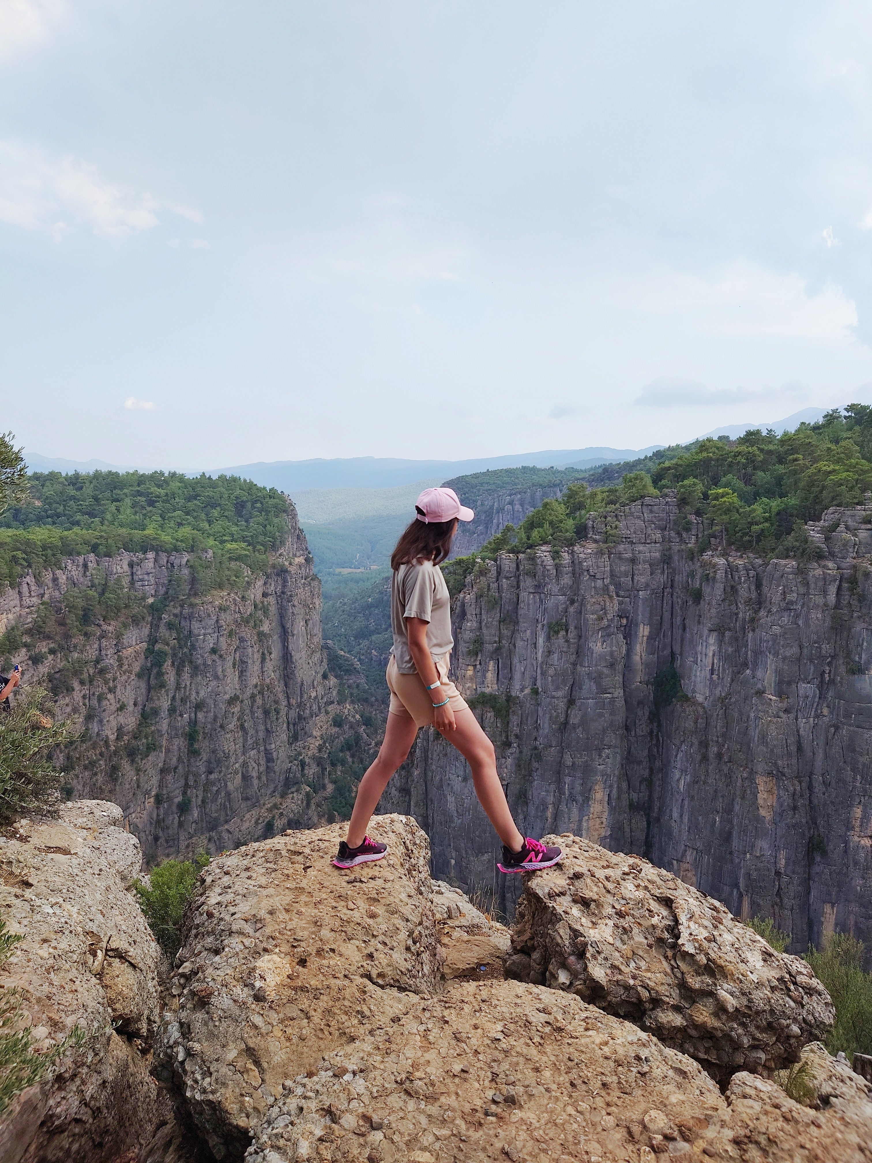Adventurous Woman Standing on Rocky Cliff Edge · Free Stock Photo