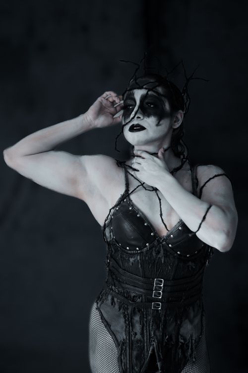 Free Artistic portrait of a woman with gothic face paint and intricate costume, embodying a dark theme. Stock Photo