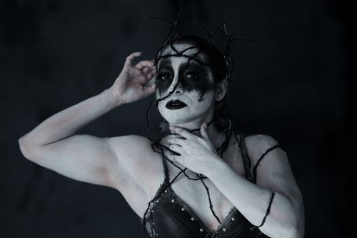 Free A striking artistic portrait of a person with dark makeup and branch-like accessories. Stock Photo