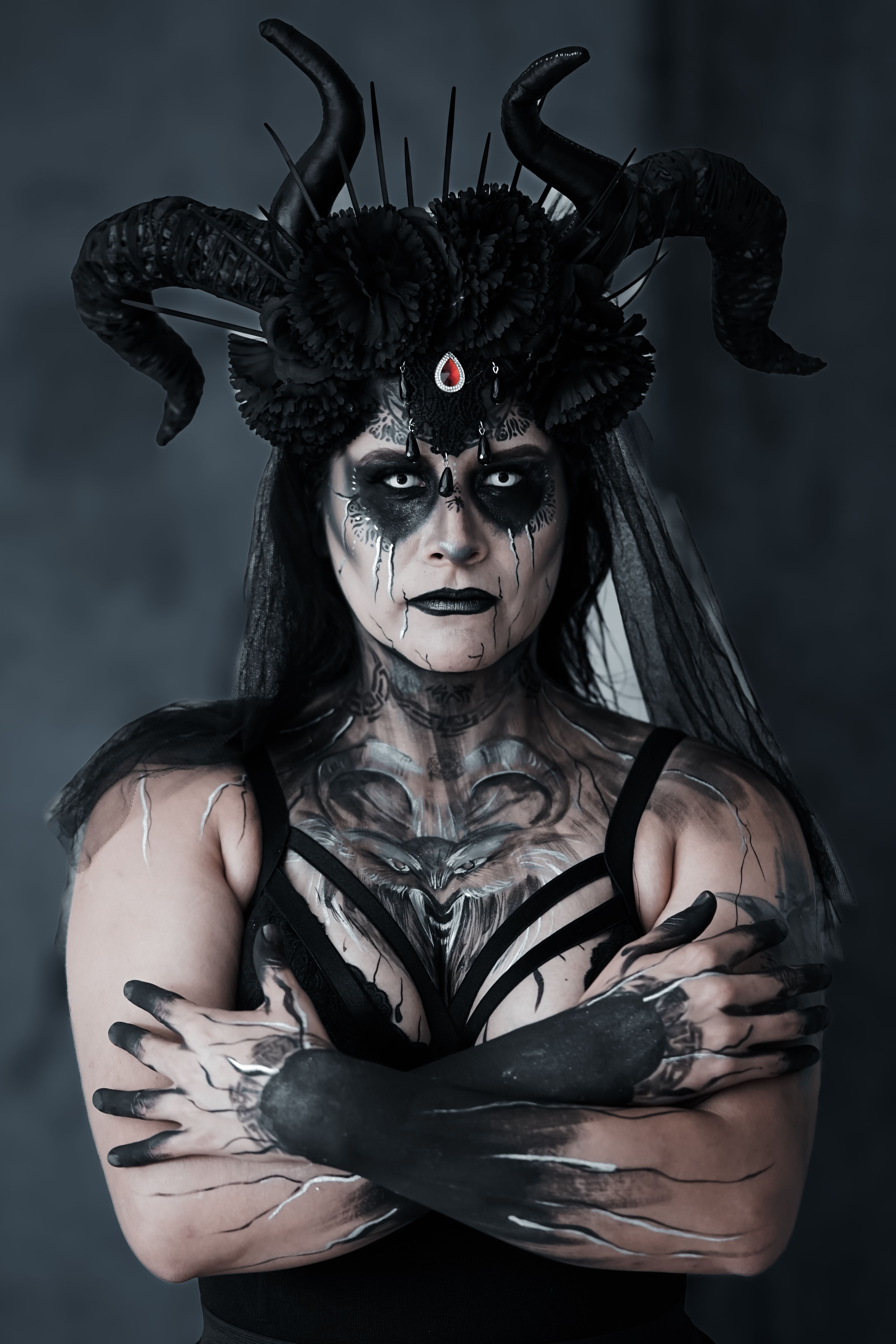 Intense gothic-themed portrait of a woman in dramatic costume and makeup.