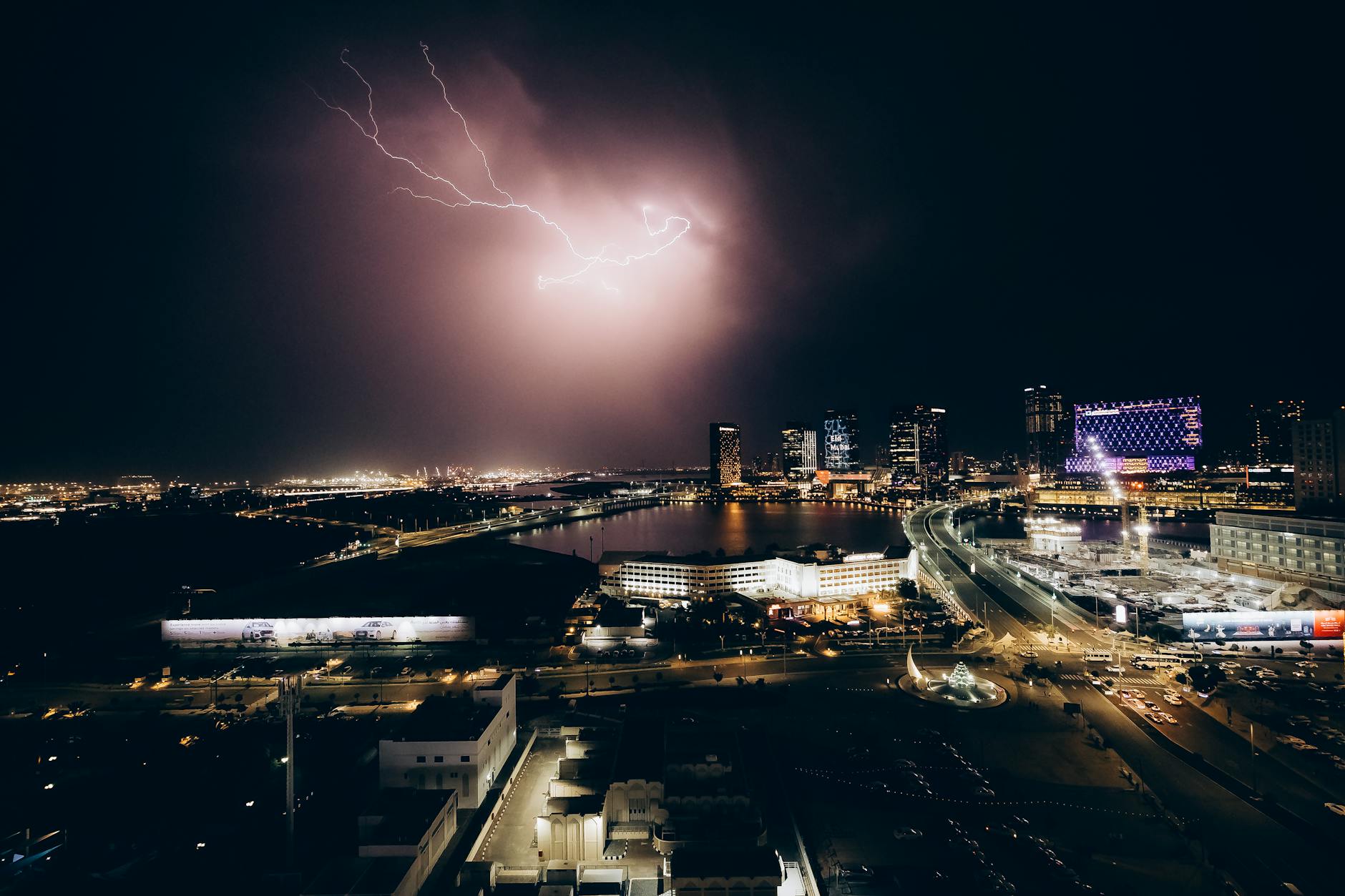A mesmerizing night view of Abu Dhabi's skyline with a dramatic lightning storm illuminating the city.