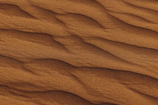 Close-up of intricate sand textures in Al Ain desert, UAE, capturing natural formations.