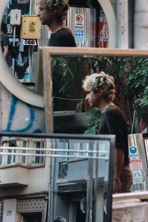 Free Captured reflections of a man in urban mirrors creating a unique street perspective. Stock Photo