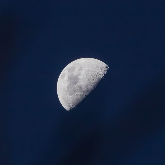 Waxing moon over a deep blue night sky, photo by Diego Fraga on Pexels