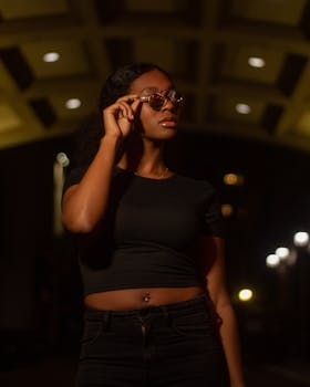 一位女子身着休闲装，戴着太阳镜，在夜间拍摄的肖像显得十分优雅