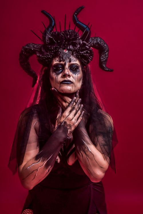 Free A striking gothic portrait of a woman with dark makeup and a horned headpiece. Stock Photo