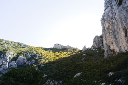 Free A serene view of rocky cliffs and lush vegetation under a clear sky. Stock Photo