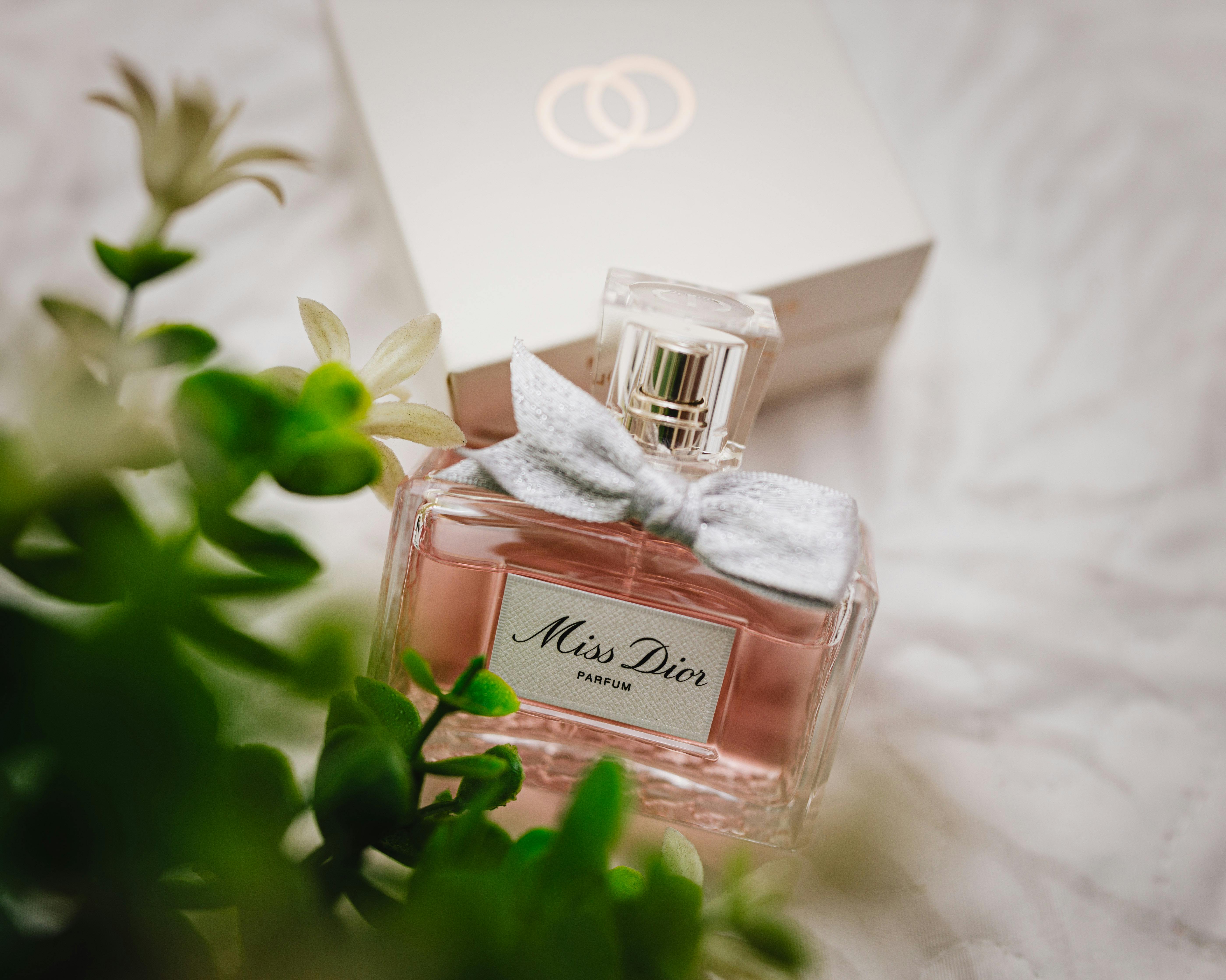 Close-up of a Miss Dior perfume bottle with soft floral background.