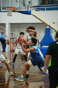 Dynamic indoor basketball action with energetic players during a heated game.