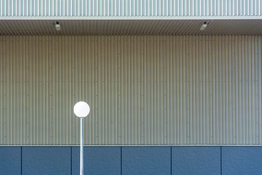 Photo of minimalist architectural design with a single street lamp against a textured wall.