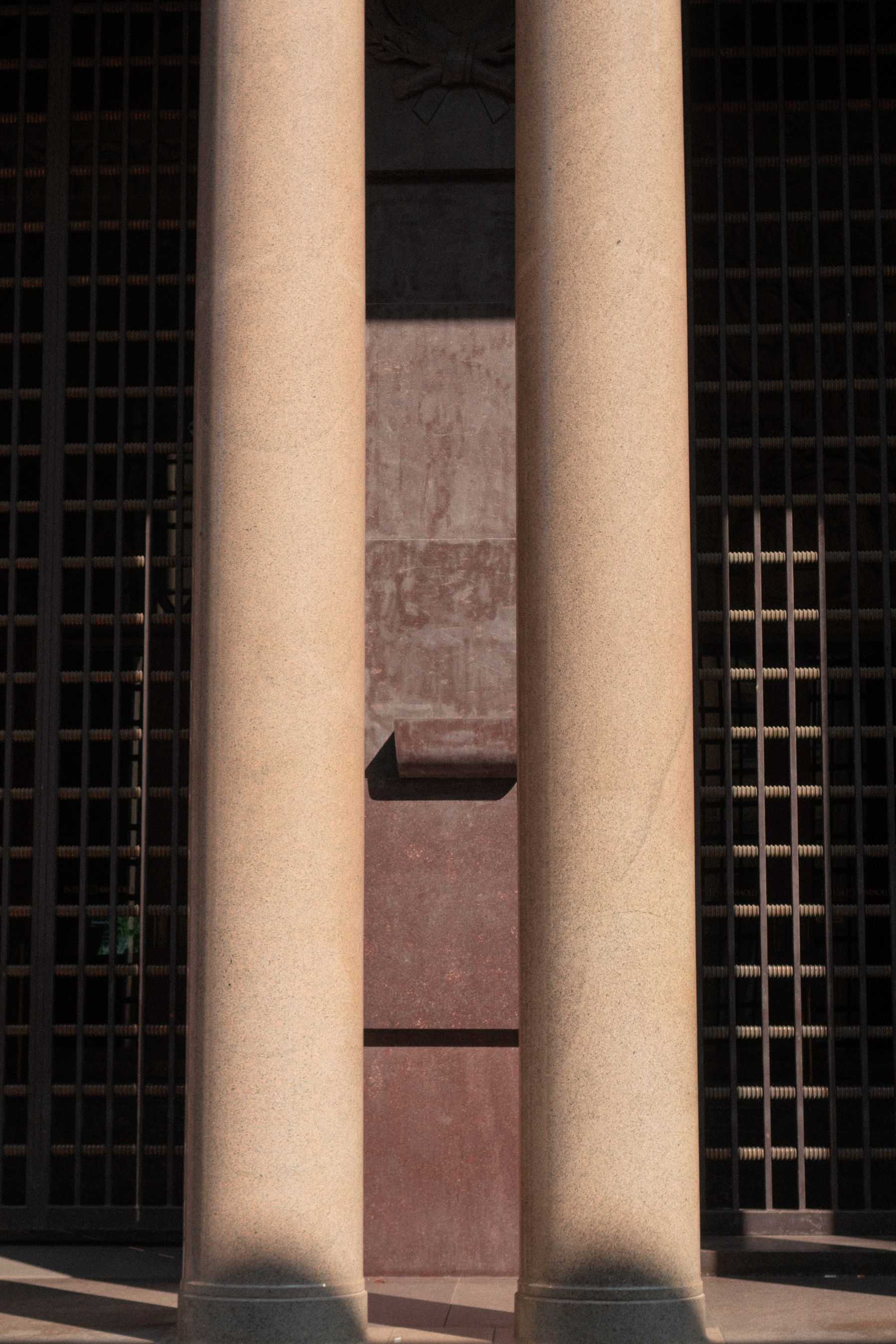 Polished stone columns between tall dark windows