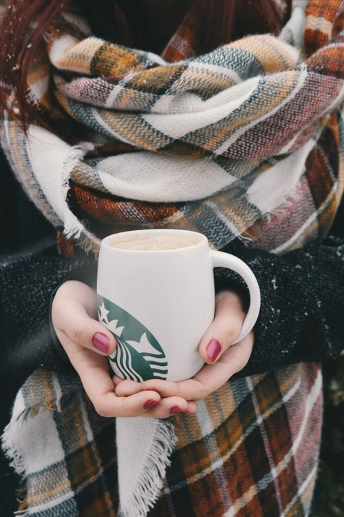 Free A woman warmly holds a coffee cup wrapped in an autumn scarf, symbolizing cozy fall vibes. Stock Photo
