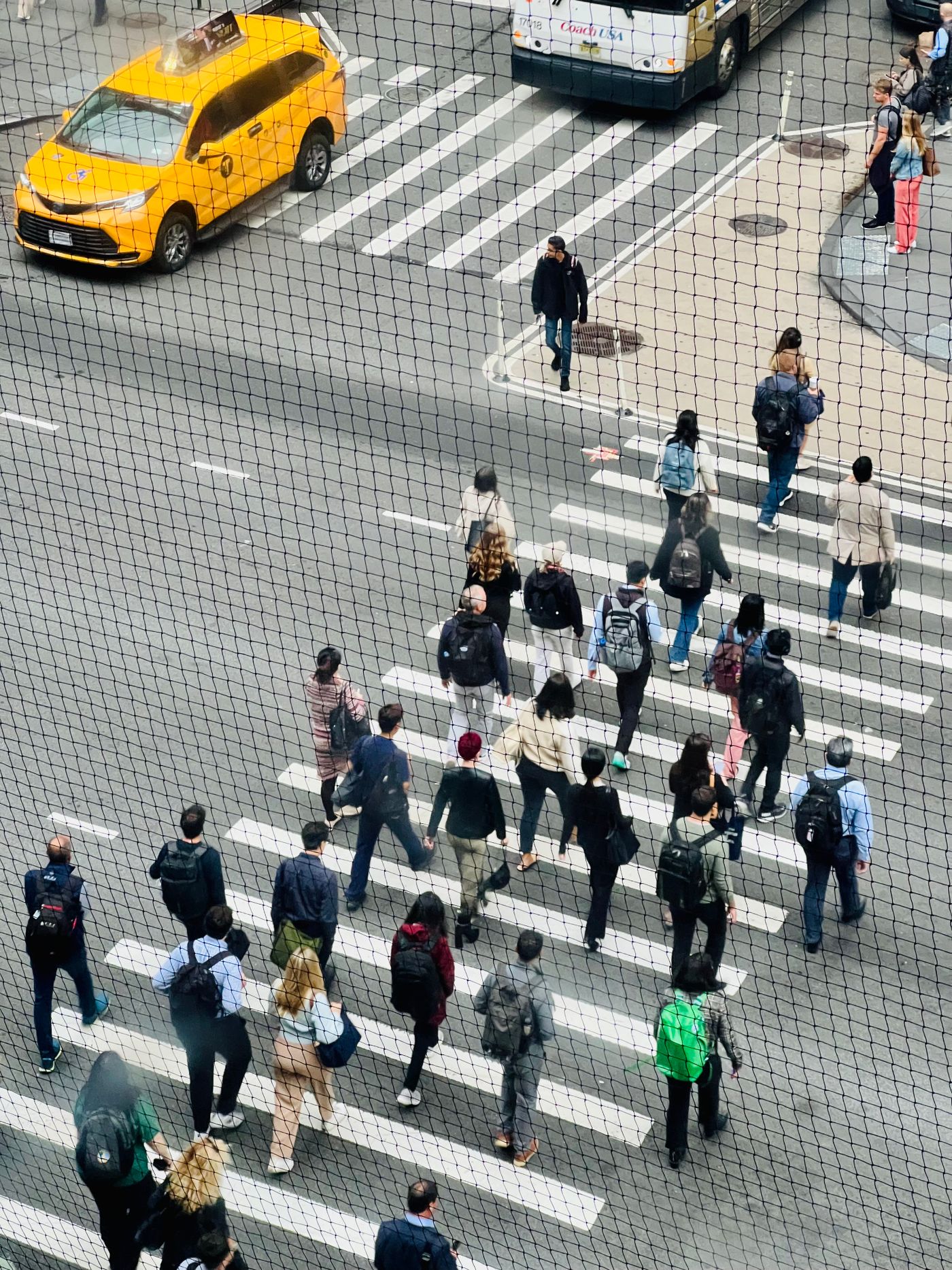 Aerial view of pedestrians crossing a busy city crosswalk.
