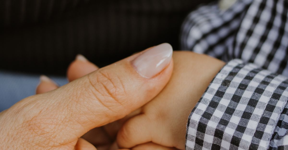 Adult Hand Holding Child's Hand in Comforting Gesture · Free Stock Photo