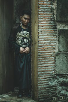 门口站着一个穿着哥特式服装的男人，表情神秘，给人一种怪异的感觉