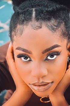 Close-up portrait capturing a young woman's intense gaze and bold eye makeup.