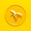 Photo of Peeled Banana on Yellow Plate and Background