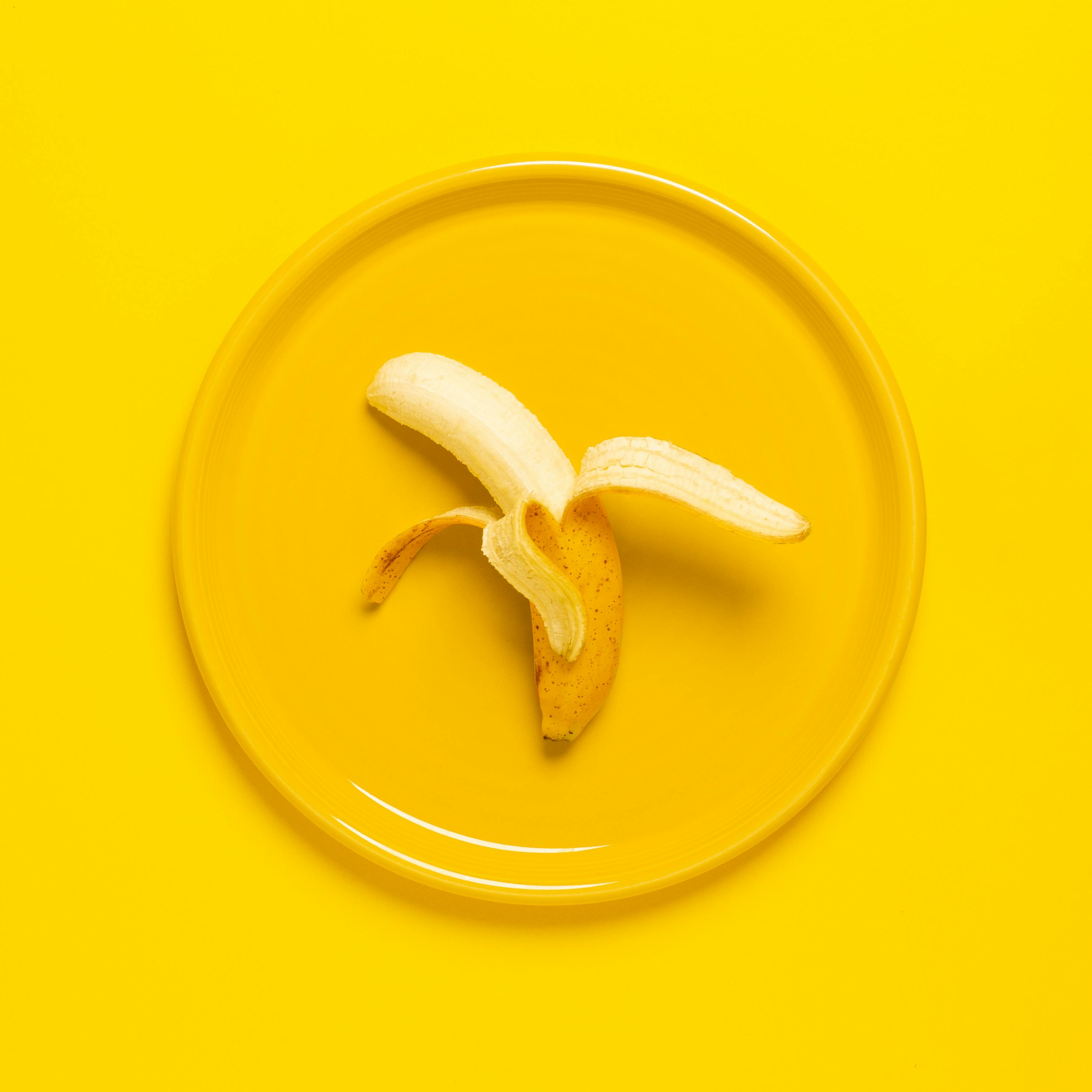 Photo of Peeled Banana on Yellow Plate and Background · Free Stock Photo