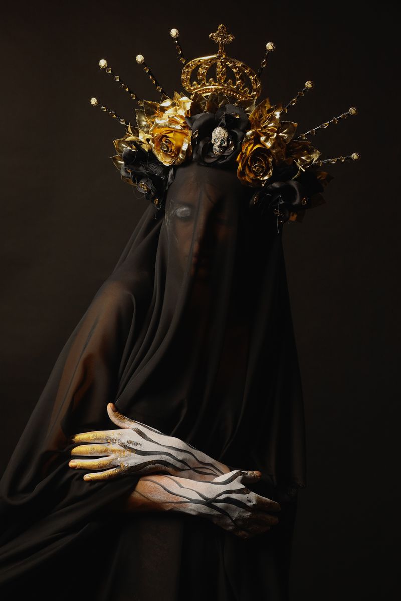 Mysterious figure draped in black veil and ornate crown, embodying dark elegance.
