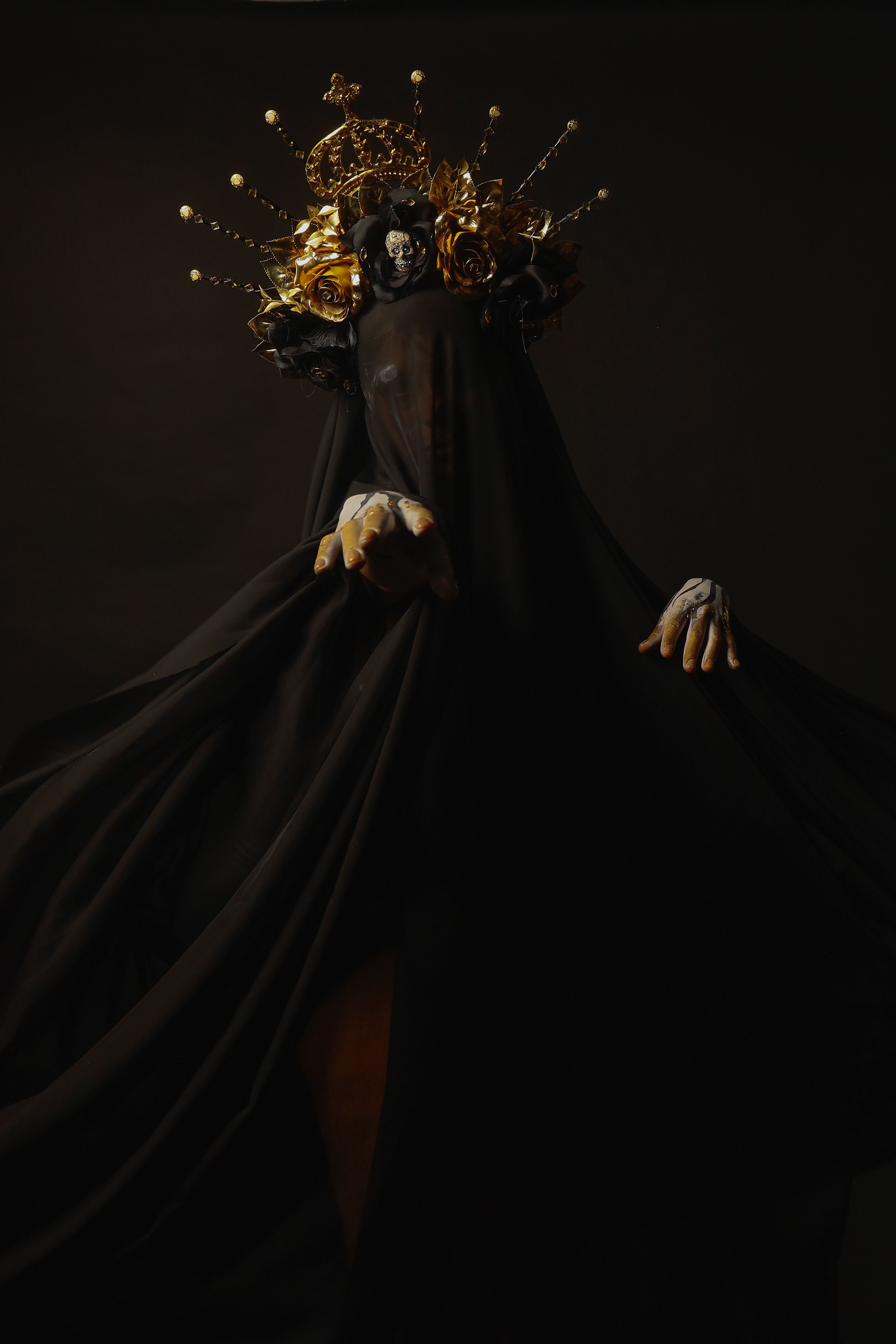 A mysterious figure adorned with a crown and shrouded in dark fabric, showcasing artistic expression.
