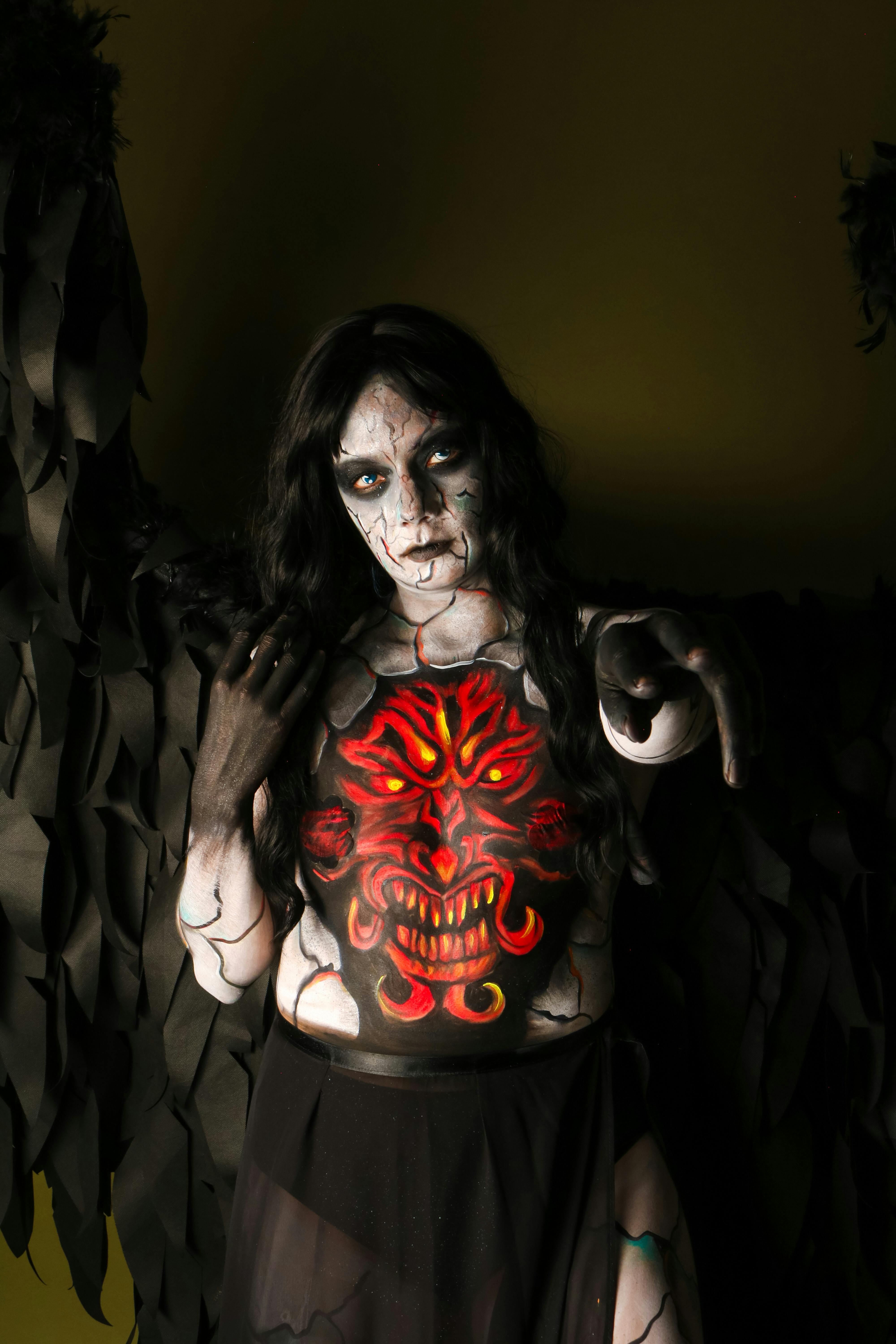 Dark fantasy character with dramatic body paint and costume, creating a mysterious atmosphere.