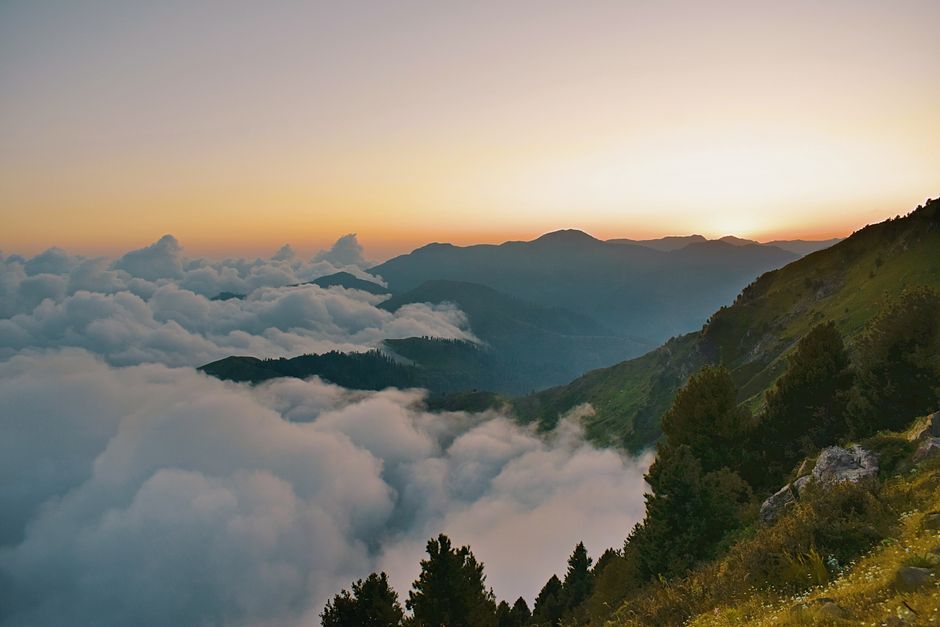 Breathtaking view of mountains and clouds at sunset in Rawalakot. Perfect nature landscape.