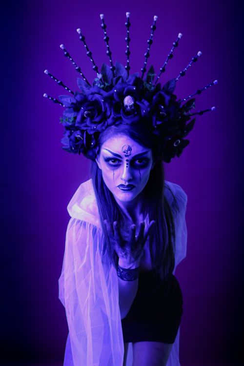 Free A woman in dark makeup and elaborate headpiece exudes mystery and artistry. Stock Photo