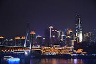 重庆夜色中，充满活力的现代天际线和灯光桥梁倒映在长江之上